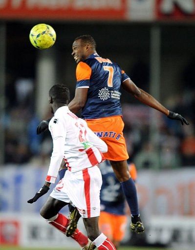 Montpellier's forward John Utaka (R) jumps for the ball over with Ajaccio's defender Fousseni Diawara